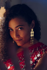 Portrait of young woman standing by wall