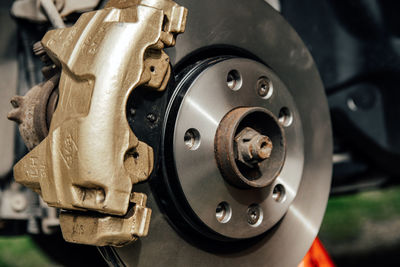 Close-up image of gold painted brake caliper on brake disc.