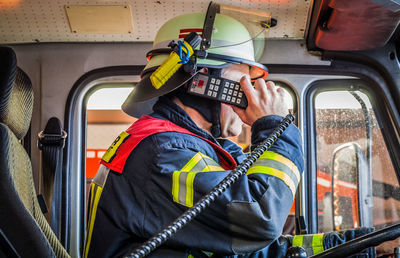 Firefighter taking emergency call in firetruck