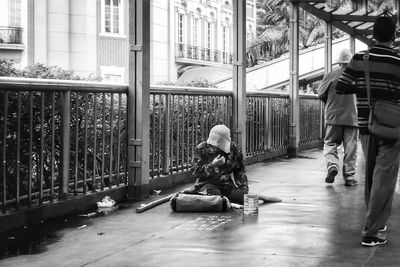 Man sitting on wall in city