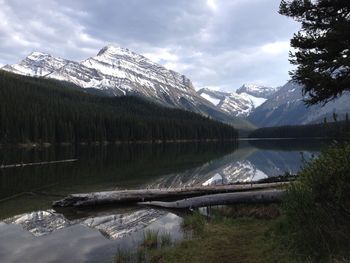 Scenic view of snow covered mountain and lake against cloudy sky