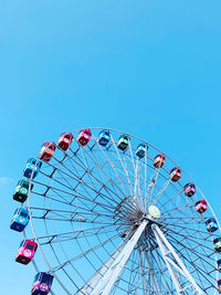 Low angle view of ferris wheel against clear blue sky