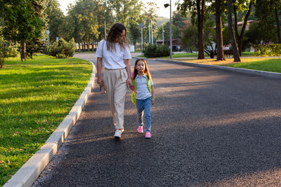 Rear view of woman walking on road