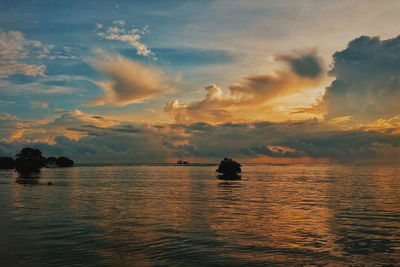 Silhouette boat in sea against sky at sunset