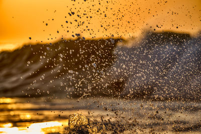 Raindrops on glass window during sunset