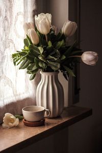 Flower vase on window sill at home