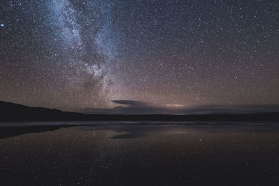 Scenic view of sea against star field at night