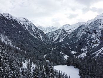 Scenic view of snowcapped mountains against cloudy sky