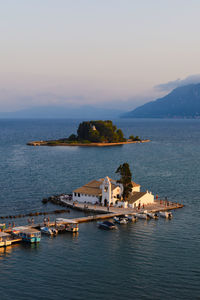 Scenic view of sea by buildings against sky during sunset