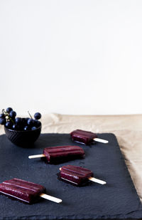 High angle view of blueberry ice creams on slate tray against white background