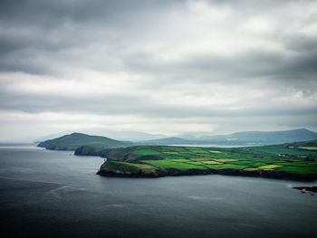 Scenic view of sea and mountains against sky