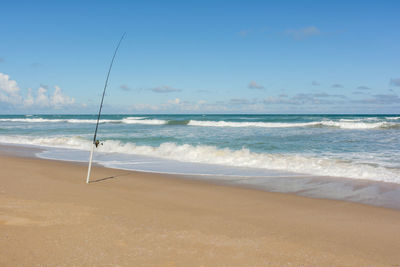 Beach fishing on a remote sandy beach on sunny day