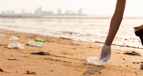 Low section of woman sitting at beach