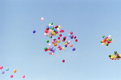 Multi colored balloons against sky