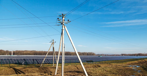 Electricity pylon on field against sky