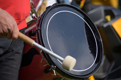 Midsection of man playing drum