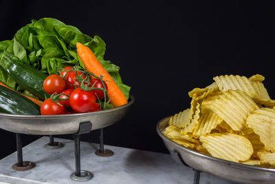 Fruits in bowl against black background