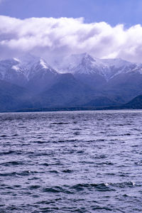 Scenic view of lake and snowcapped mountains against sky