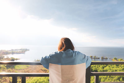Rear view of woman looking at sea against sky