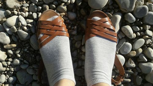 Low section of person standing on pebbles