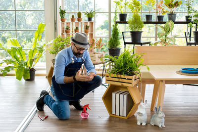 Full length of young man sitting on table at home