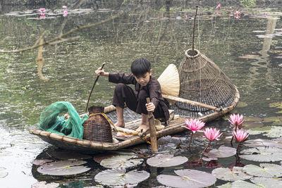 Rear view of man standing by lake