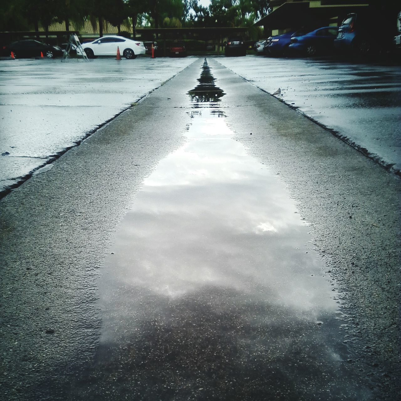 water, puddle, wet, reflection, rain, street, architecture, building exterior, built structure, transportation, weather, mode of transport, city, car, season, land vehicle, drop, monsoon, road, day