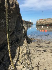 Rock formation on beach against sky