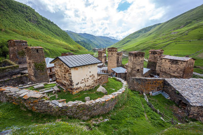 Scenic view of houses and mountains against sky