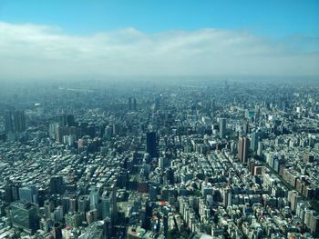 High angle view of cityscape against cloudy sky