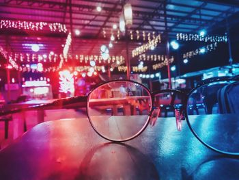 Close-up of eyeglasses on table in illuminated restaurant