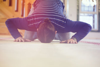 Man praying on floor at home