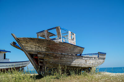 Abandoned structure on field against clear blue sky