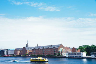 Boats in river with buildings in background