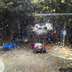 Cars on road seen through wet window in rainy season