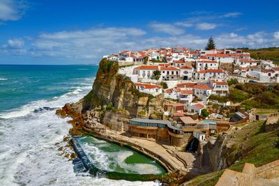 Panoramic view of sea and buildings against sky