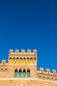 Low angle view of historical building against clear blue sky