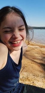 Cheerful girl sitting at beach