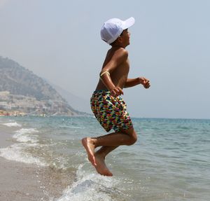 Full length of woman on beach against clear sky