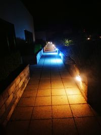 Illuminated street amidst buildings at night