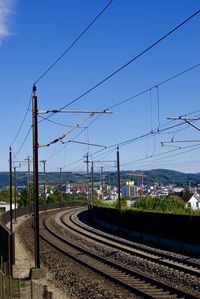 Railroad tracks in city against sky