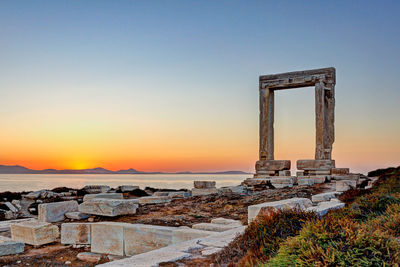 Built structure in sea during sunset