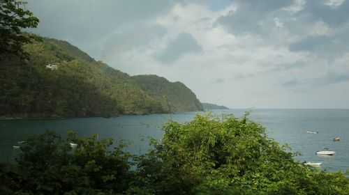 Scenic view of sea and mountains against sky