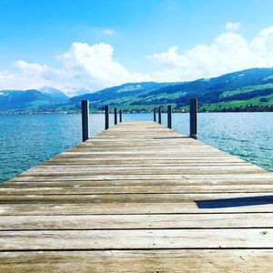 Wooden pier over lake against sky