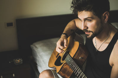 Man playing guitar at home