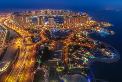 High angle view of city lit up at night