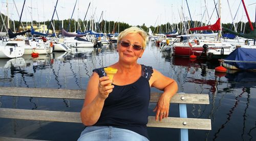 Portrait of young woman in boat moored at harbor