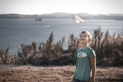 Portrait of boy standing on land against sky