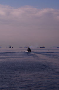 Silhouette ship sailing on sea against sky during sunset