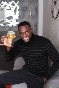 Portrait of a smiling young man drinking glass